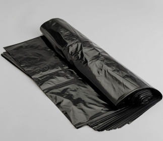 A roll of black bin liners unraveling to show the numerous amounts included in the roll.  