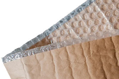 Close up image of bubble wrap featuring clear plastic bubbles on one side and sturdy brown kraft paper on the other illustrating its dual layer construction. 